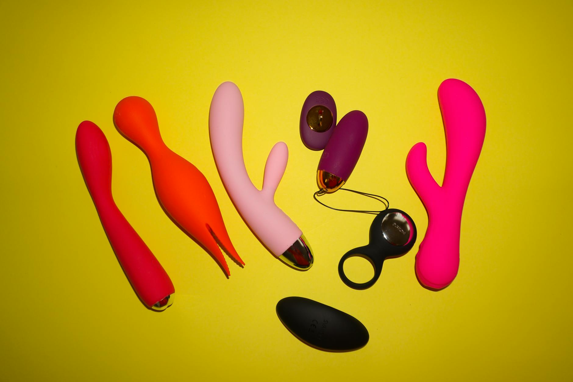 Colorful clitoral vibrators displayed on a bright yellow background